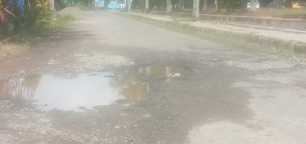 Kondisi jalan di Depan Kantor Dinas Kesehatan Kabupaten Mamuju, berlubang hingga digenangi air (Foto Bahri Rakyat Sulbar.com)