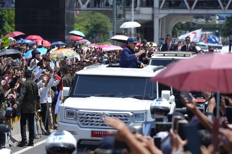 Presiden Prabowo Subianto melambaikan tangan kepada masyarakat yang menunggu di Jalan Sudirman, Jakarta, Minggu (20/10/2024). Pelantikan Presiden Prabowo Suboianto dan Wakil Presiden Gibran Rakabuming Rakadihadiri oleh pejabat tinggi negara dan perwakilan dari negara sahabat.