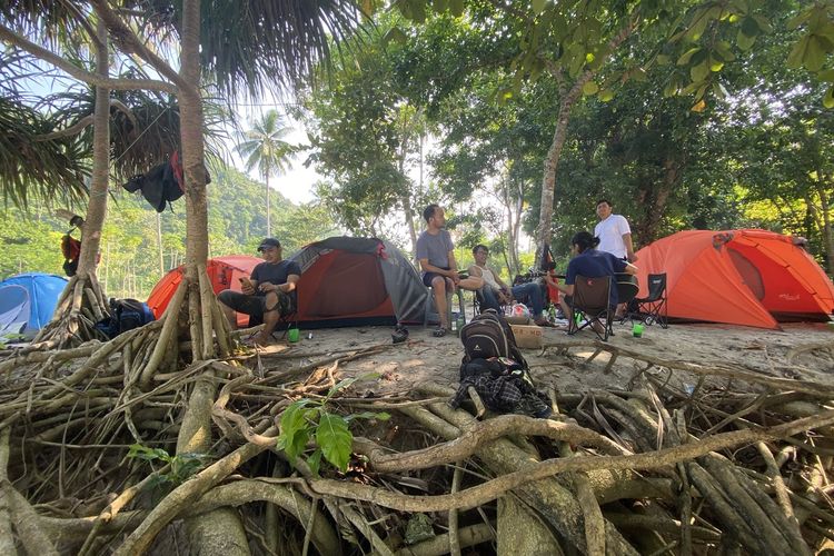 Pengunjung berkemah di Pantai Teluk Hantu, Sabtu (5/8/2023).